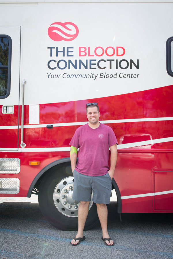 Donator Standing under The Blood Connection on the Bus.