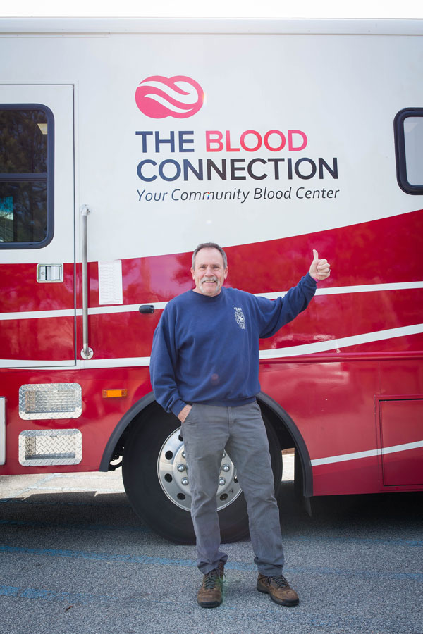 Donator Standing under The Blood Connection on the Bus.